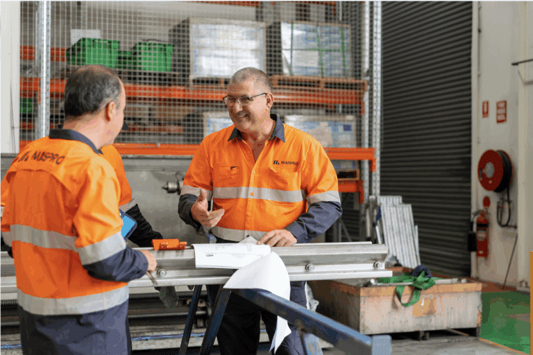 MASPRO team members discussing locally manufactured mining components in an Australian engineering and production facility.
