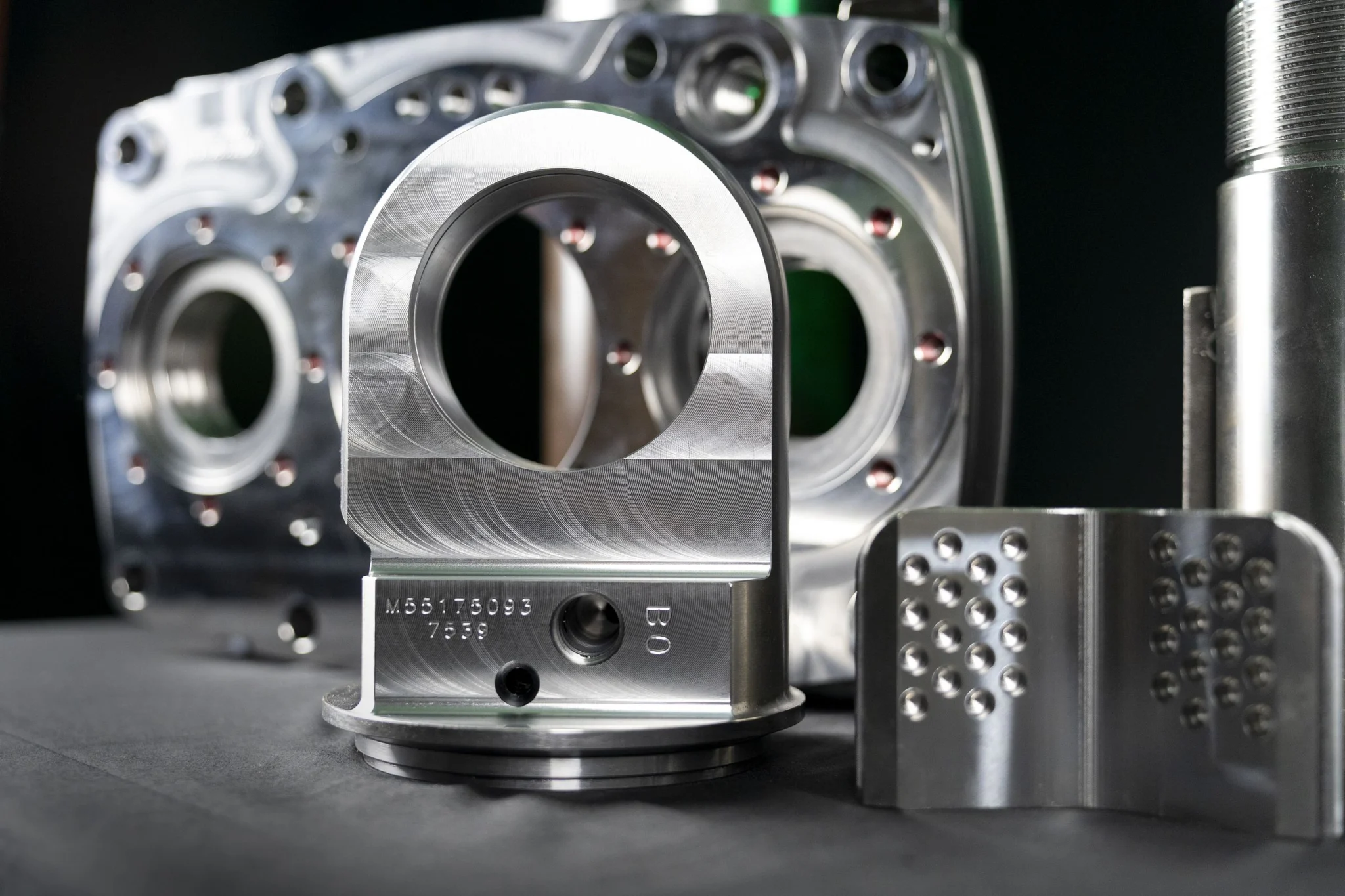 Machined rotation head and drilling components arranged in studio product photography.