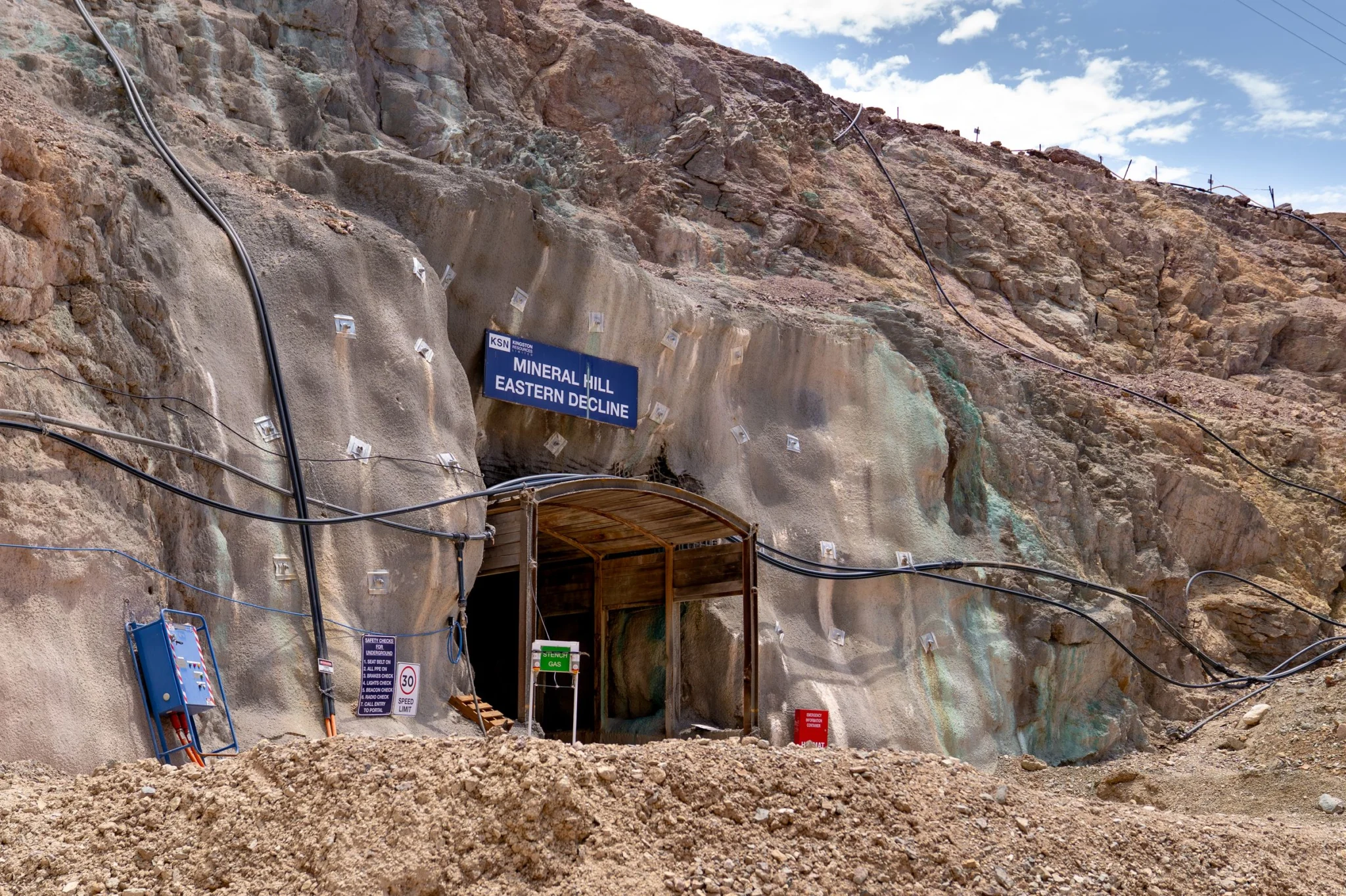 Underground mine entrance with 'Mineral Hill Eastern Decline' signage and timber pit props supporting the portal.